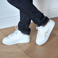 Sneakers in simil pelle con ricamo laterale